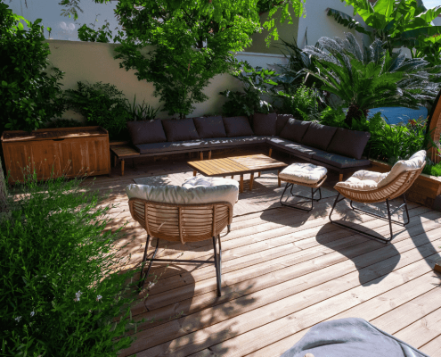 Espace détente ombragé avec terrasse en bois et plantes luxuriantes – aménagement paysager par Au Jardin des Rêves à Pornic