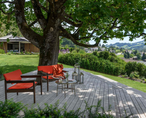 Terrasse en bois sous un grand arbre d’ombrage – aménagement paysager naturel par Au Jardin des Rêves à Pornic