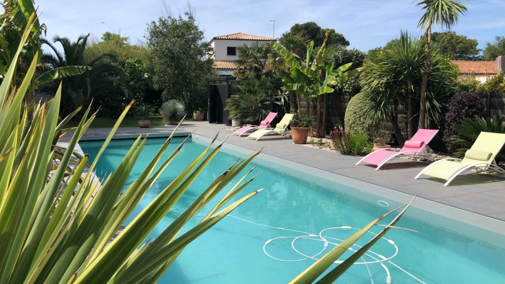 piscine-jardin-exotique-amenagement-paysager-palmiers-au-jardin-des-reves Piscine extérieure aménagée dans un jardin paysager exotique avec palmiers, bananiers, transats et terrasse contemporaine à Paimboeuf.